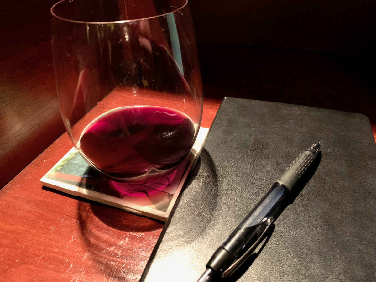 glass of red wine and moleskine notebook