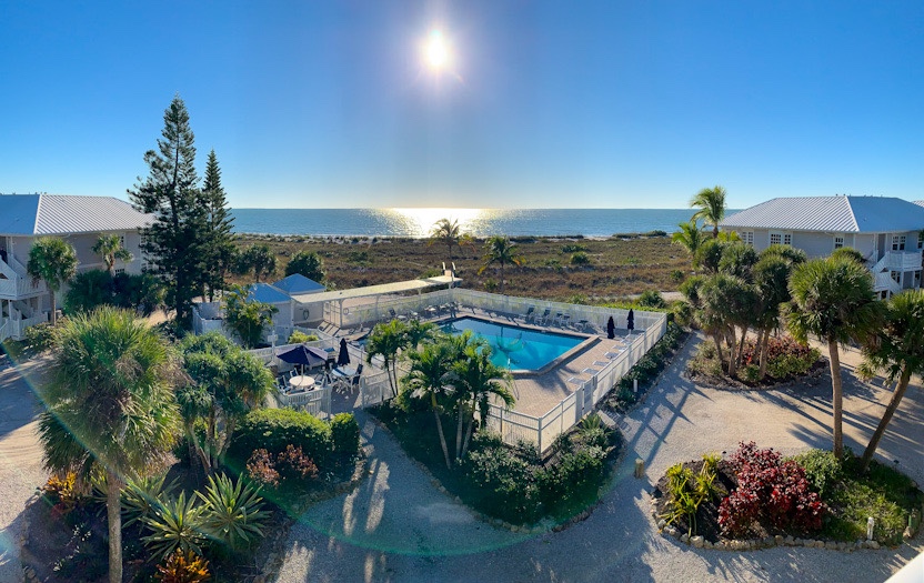 Panorama view of the beach, with pool at center and condos at left and right.