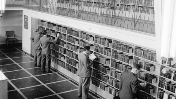 Men looking at books in library