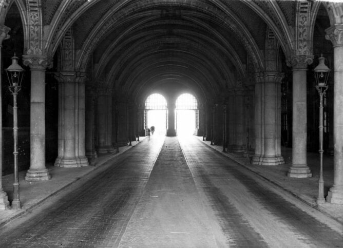 black and white photograph of two archways at the end of a long hall