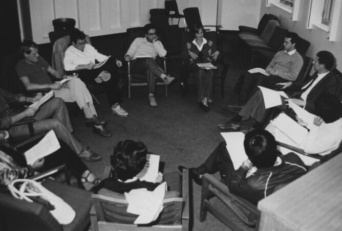 group of students sitting in a circle talking and taking notes
